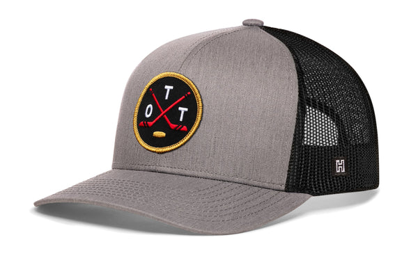 Gray trucker snapback cap with hockey logo patch and black mesh side panels