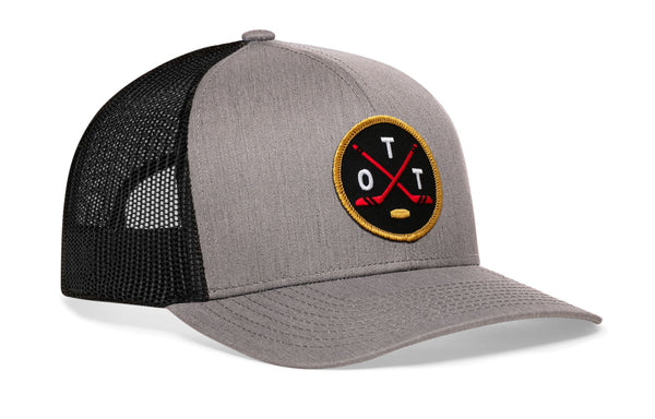 Gray front trucker snapback cap with hockey logo patch and black mesh side