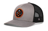 Gray trucker cap with black mesh back and orange circular logo patch, curved brim