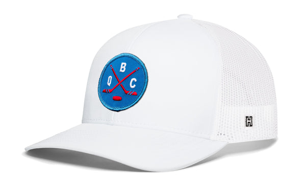 White hockey trucker cap with blue front logo patch and mesh side panels, curved brim