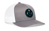 Gray trucker cap with white mesh side panel, circular front logo patch, and curved brim.