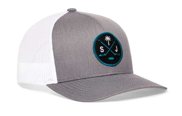 Gray trucker cap with white mesh side panel, circular front logo patch, and curved brim.