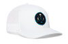 White trucker cap with mesh side panel, circular front logo patch, and curved brim.