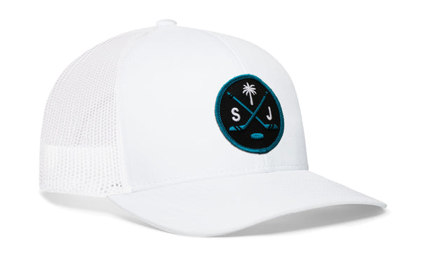 White trucker cap with mesh side panel, circular front logo patch, and curved brim.
