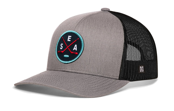 Gray snapback trucker hat with black mesh back and circular SEA X logo patch