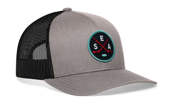 Gray trucker hat with black mesh sides, curved brim, and SEA X logo patch