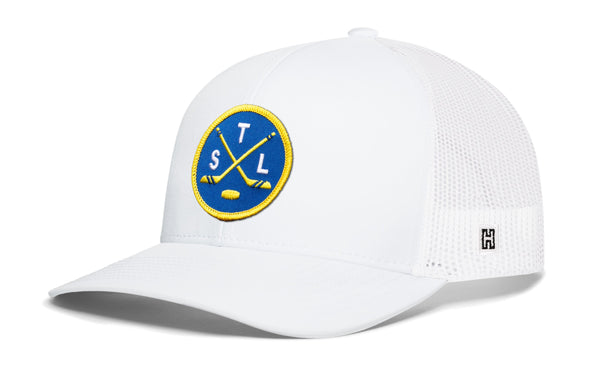 White trucker hat with front logo patch and mesh back panels.