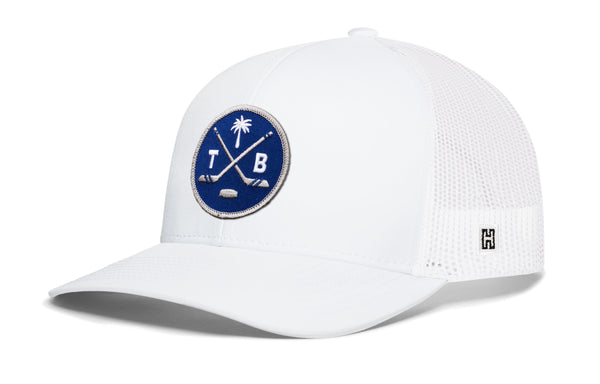 White trucker hat with blue circular logo patch and white mesh side panels