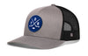 Gray-and-black trucker snapback hat with mesh sides, blue logo patch, and H emblem.