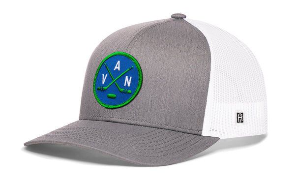 Gray front trucker snapback cap with green logo patch and white mesh side panels