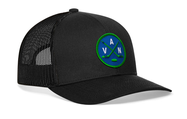 Black trucker snapback cap with green logo patch and black mesh side panels