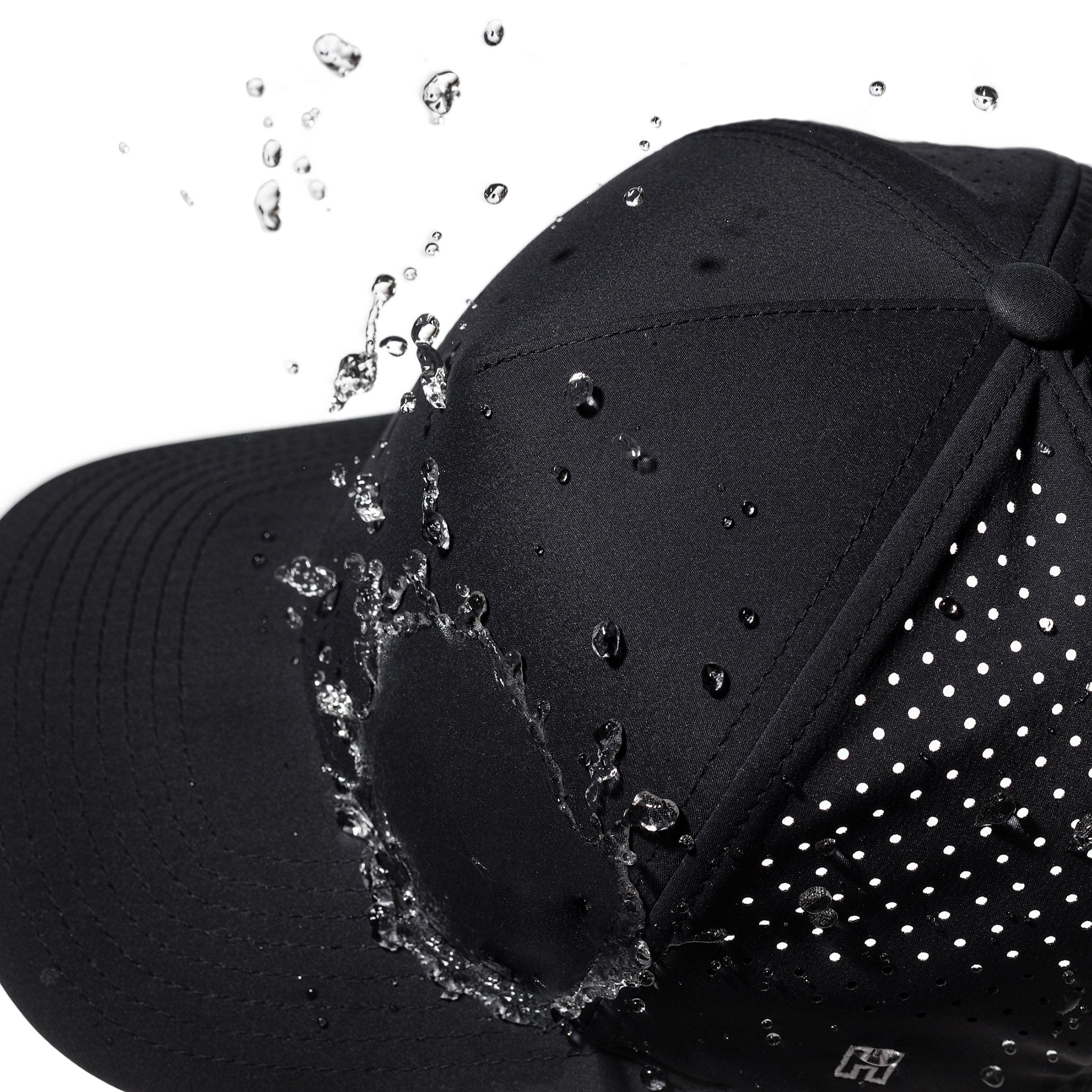 Black performance cap close-up with water droplets on side panel and brim