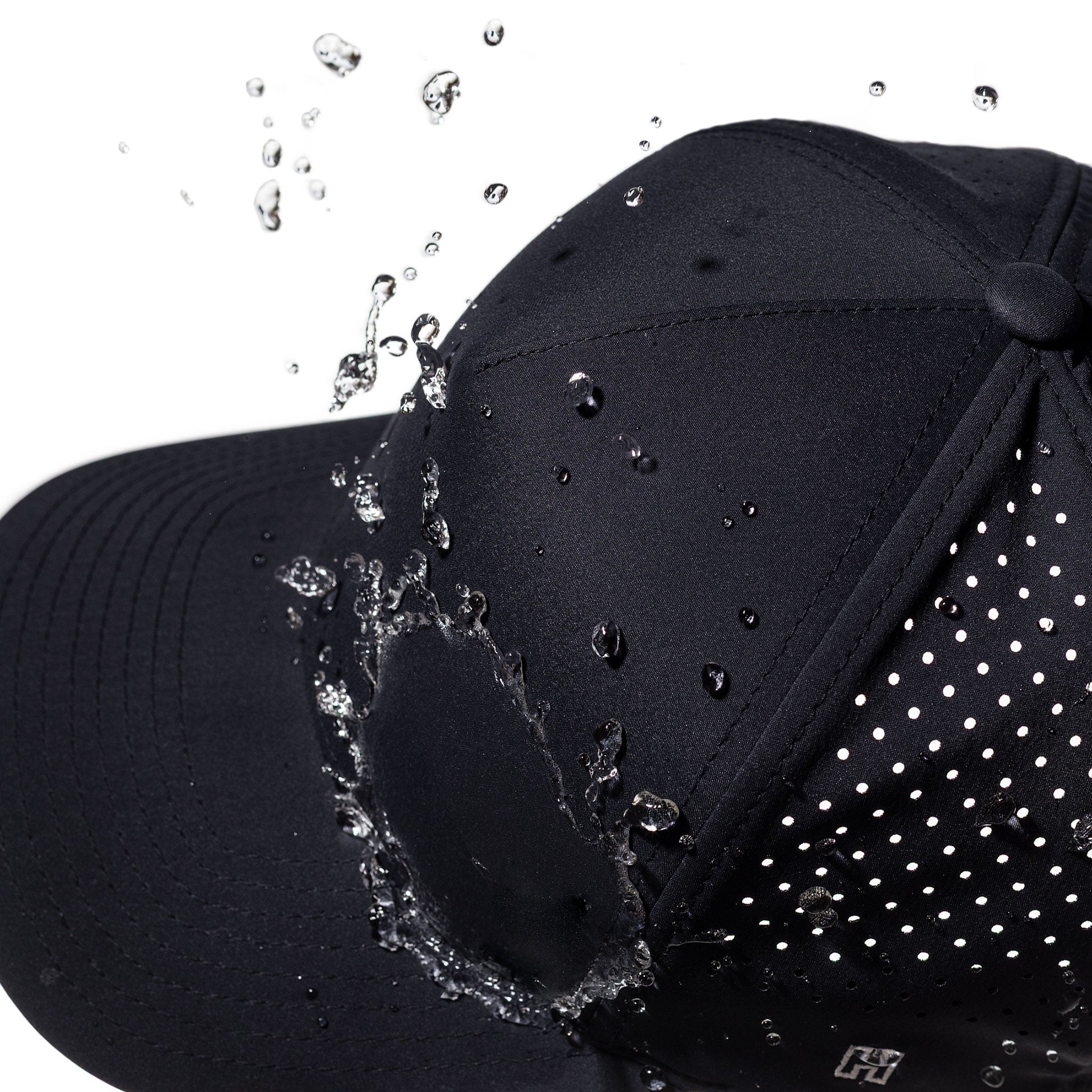 Black 5-panel hat close-up with water droplets on front panel and perforated brim