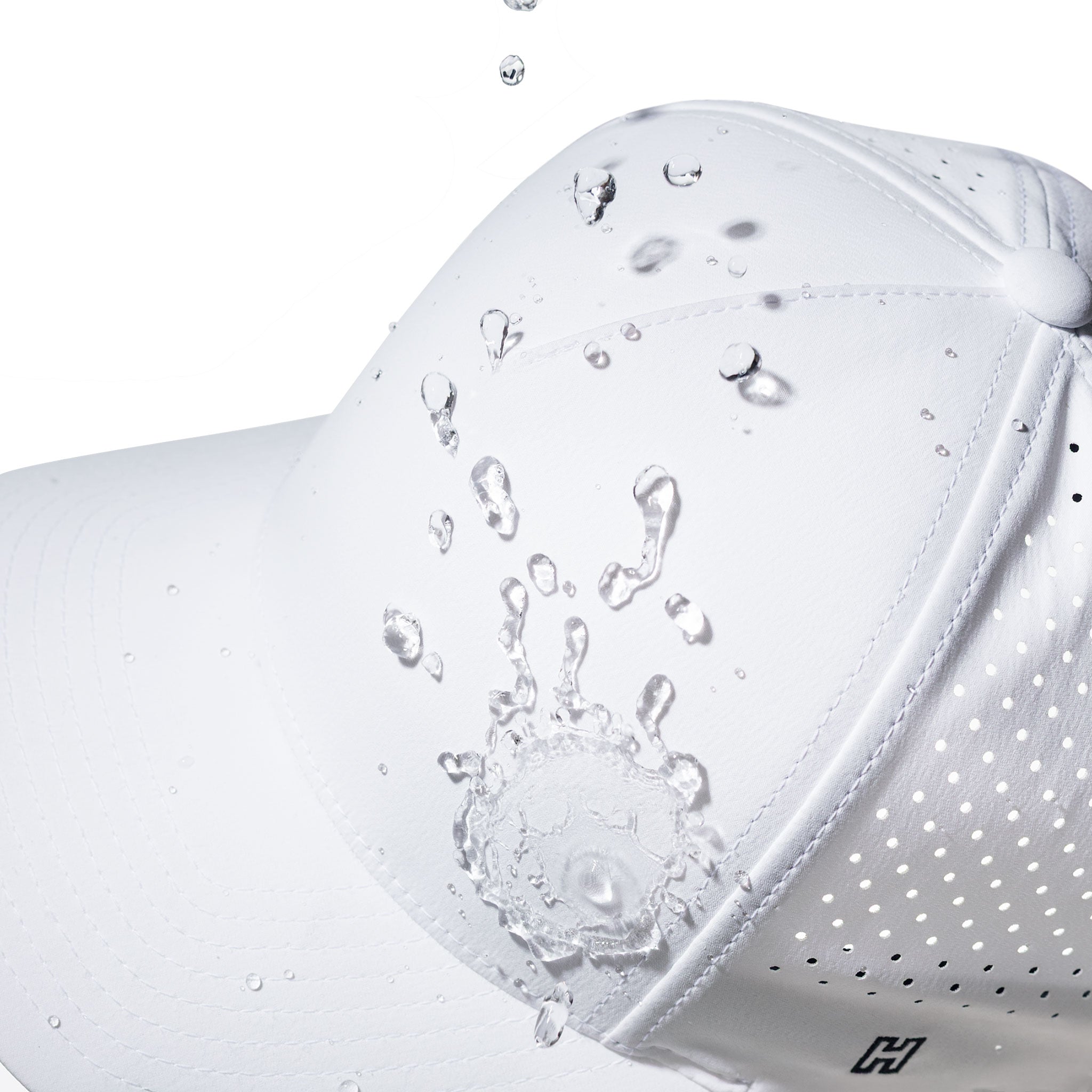 White performance hat close-up with beaded water droplets on fabric and brim