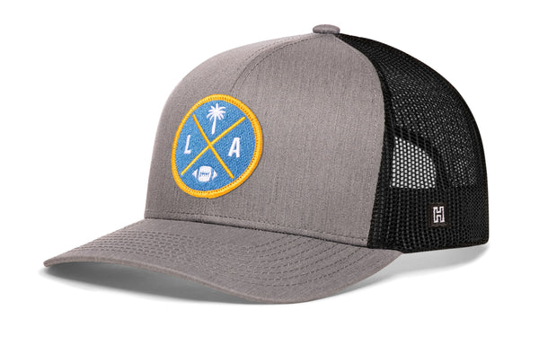 Gray front trucker cap with LA X logo patch, black mesh side panels, snapback