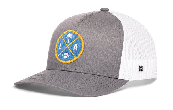 Gray front trucker cap with LA X logo patch, white mesh side panels, snapback