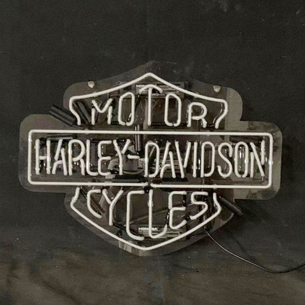 Harley-Davidson motorcycle neon sign with white-blue glow on dark backdrop and cable