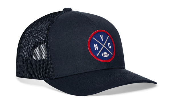 Dark navy trucker snapback hat, side view with round logo patch and mesh panels