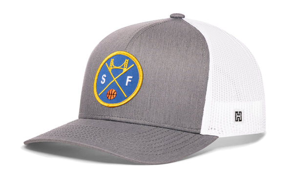 Gray front trucker cap with basketball-style logo patch and white mesh side panels