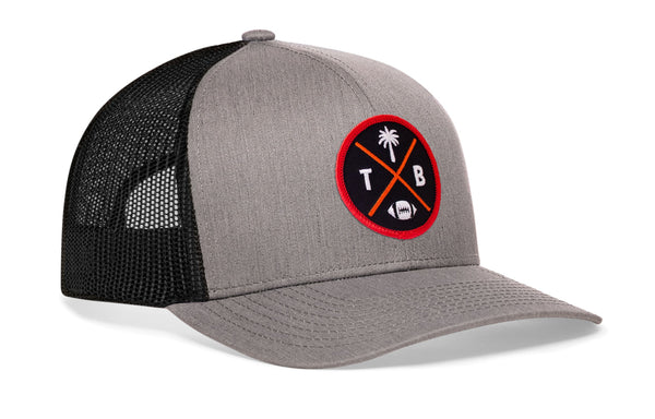 Gray trucker hat with red circular logo on the side, curved brim, and black mesh back