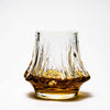 Crystal whisky tumbler with fluted sides filled with amber whisky