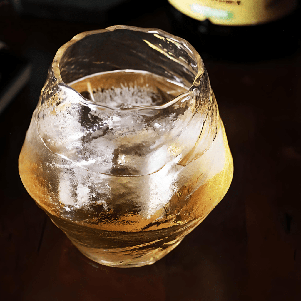 Faceted crystal whisky glass with amber liquid, flared rounded shape