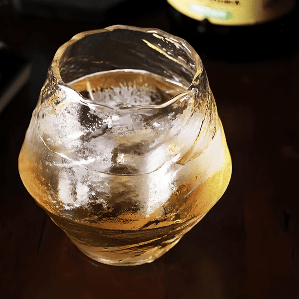 Faceted crystal whisky glass with amber liquid, flared rounded shape