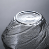 Close-up of faceted crystal whisky glass top rim with textured sparkle surface