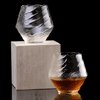 Faceted crystal whisky glass with amber liquid on a wood coaster